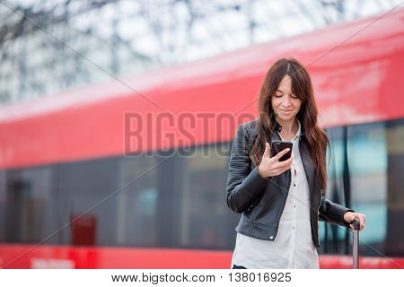 Young woman with luggage on the platform waiting for aeroexpress