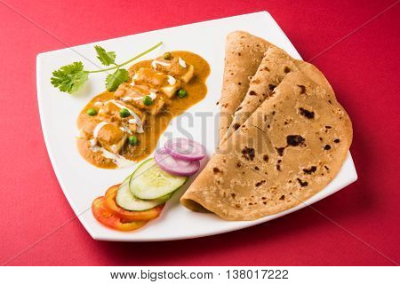 indian food paneer butter masala served with chapati / roti / paratha / fulka / indian bread with green salad