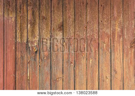 The vertical boards are old and cracked wood with knots