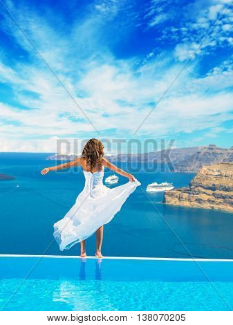 Bride standing on the edge on the infinity pool in Greece