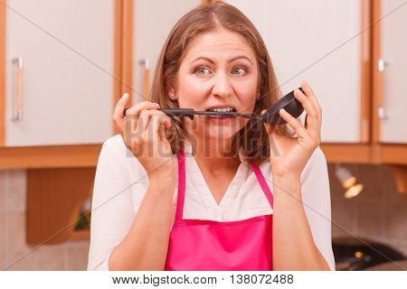 Housewife With Ladle In Kitchen