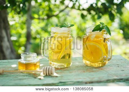 Iced tea with lemon slices and mint. A refreshing drink on a hot summer day in the garden. Shallow depth of field