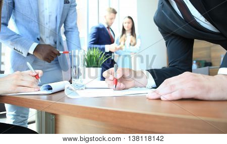Image of business team sitting at the table and discussing a new project