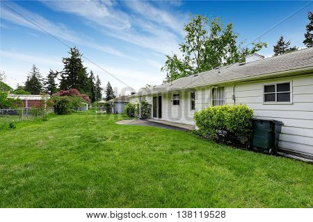 Back Yard Of American Rambler With Green Grass And Lots Of Space