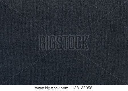 Dark blue background from a textile material. Fabric with natural texture. Cloth backdrop.