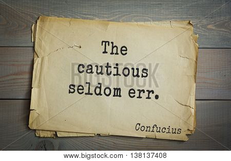 Ancient chinese philosopher Confucius quote on old paper background. The cautious seldom err.