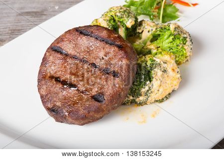 Fried beef cutlet served with broccoli garnish