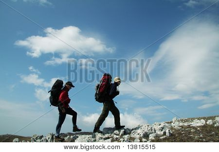 Dos personas subiendo a lo largo de la colina