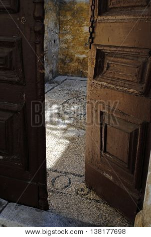 weathered patio doors and mosaic fragment of sea pebbles