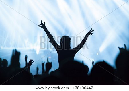 Crowd at concert - Cheering crowd in front of bright colorful stage lights