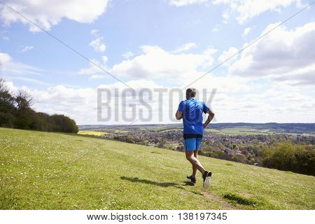 Rear View Of Mature Man Jogging In Countryside