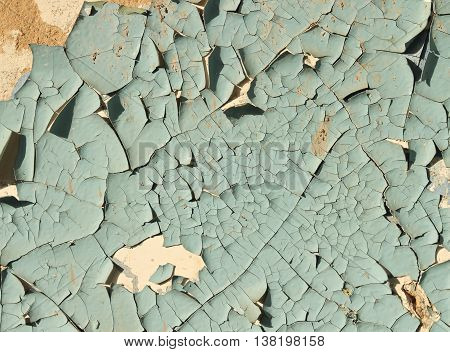Old cracked paint blue on top of a white wall, side lighting sunlight