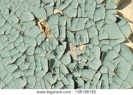 Old cracked paint blue on top of a white wall, side lighting sunlight