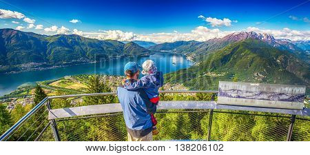 Father and his son enjoying the view to Locarno city from Cardada mountain Swiss Alps Switzerland