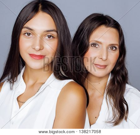 cute pretty teen daughter with mature mother hugging, fashion style brunette makeup close up, real happy family