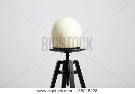 classic motorbike fullface helmet, blank, ivory, isolated on white on black luxury presentation chair, back side