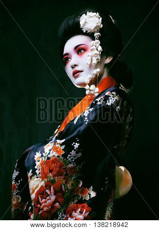 Young beautiful asian woman's portrait, geisha in kimono on black
