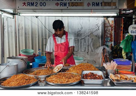 GEORGE TOWN MALAYSIA - MARCH 22: Man sells kway teow noodles at the Kimberly Street Food Night Market on March 22 2016 in George Town Penang Malaysia.