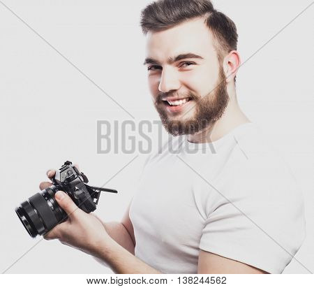 young bearded photographer taking pictures with digital camera.
