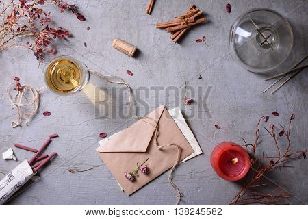 Invitation or love letter, glass of wine, burning candle and aromatic sticks. Valentine's day or Weding day background.