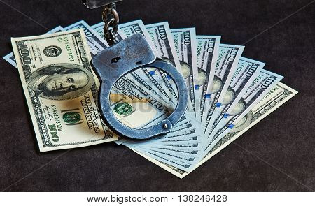 Metal handcuffs on the US currency bills