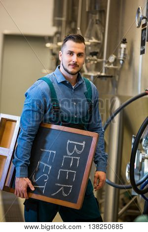 Portrait of bewer holding placard at bewery