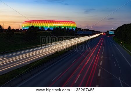 MUNICH, GERMANY - JULY 9, 2016: Long exposure of a highway at night with Allianz Arena, colored in rainbow colors for CSD weekend, Munich, Bavaria, Germany