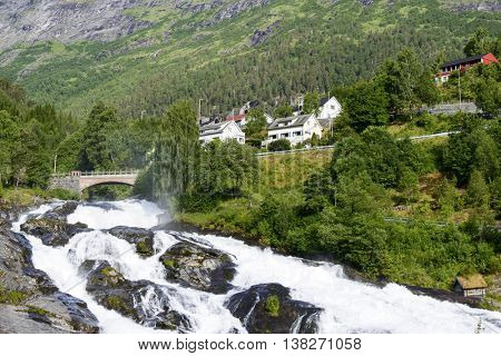 Bridge in Hellesylt on rushing mountain river.