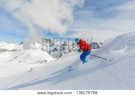 Skier skiing downhill in high mountains, San Martino di Castrozza in Italy