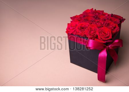 Black Box With Beautiful Red Rose Flowers Over Beige Background