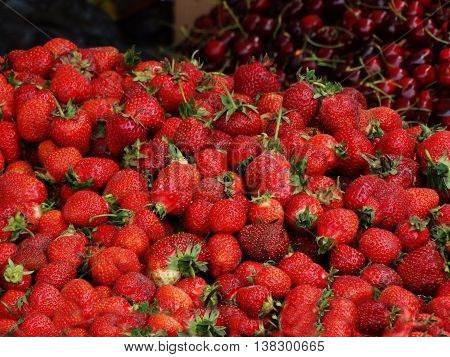 red strawberry lying in a pile on the counter market