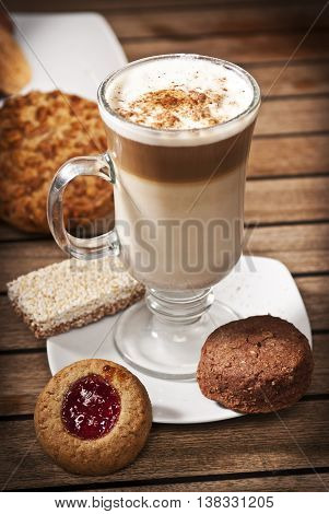 Capuchino coffe and cookies in a table