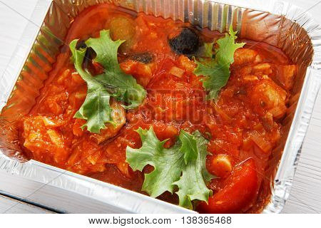 Healthy lunch and diet concept. Take away of fitness food. Weight loss nutrition in foil boxes. Hungarian lesco with tomatoes and peppers at white wood, closeup