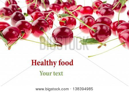Cherry background. Bunches of ripe juicy rich shiny cherries on a white background. Isolated. Decorative fruit frame. Fresh ripe cherries with tails and leaves. Fruit background. Copy space.