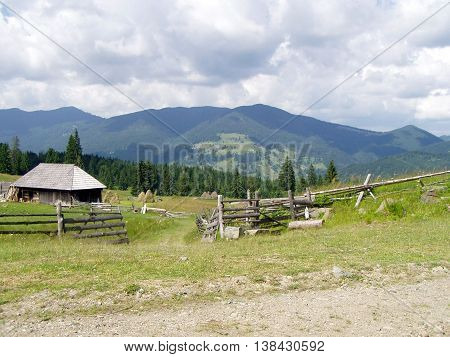 View of mountain walley with little wooden house