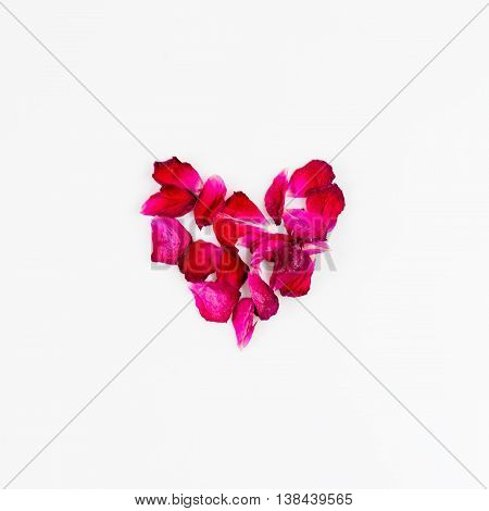 Heart made of rose petals. Tea rose petals heart over white background. Top view with copy space for your text. Love and romantic theme