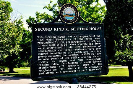 Rindge New Hampshire - July 13 2013: Town sign tells the history of the colonial-era 1796 Meeting House church on the Village Green
