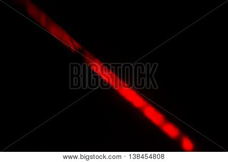 Bright Red Laser Light Shining Visibly Through Fog in Blackness