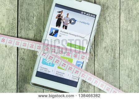 BUNG KAN THAILAND - FEBRUARY 21 2016: smart phone display runtastic app and measure tape on office desk