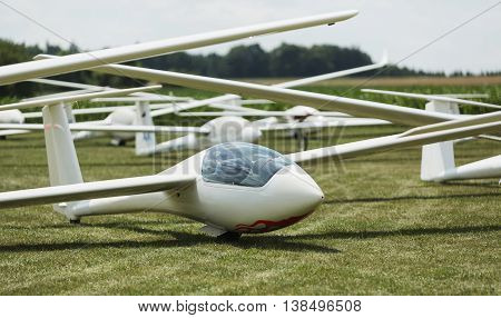 gliders at green airfield with blue sky