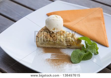 Apple pie dessert decorated with vanilla, mint and cinnamon .