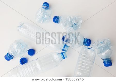 recycling, reuse, garbage disposal, environment and ecology concept - close up of empty used crashed plastic water bottles on table