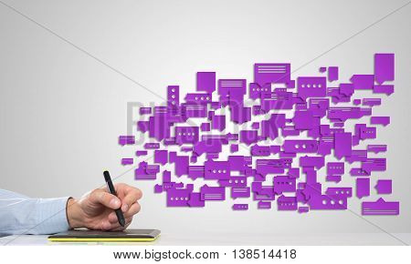 Hand of man using tablet and chatboxes flying out