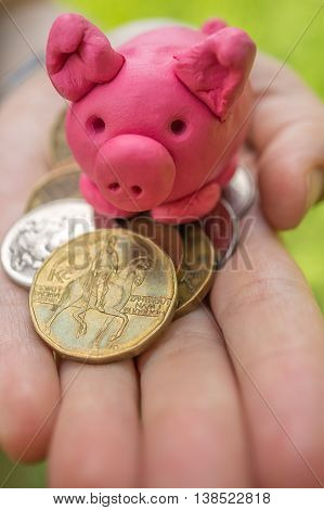 Hand is holding pink piggy - moneybox as symbol of savings