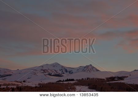 Pink solnedgang skyer over sneklædte bjerge