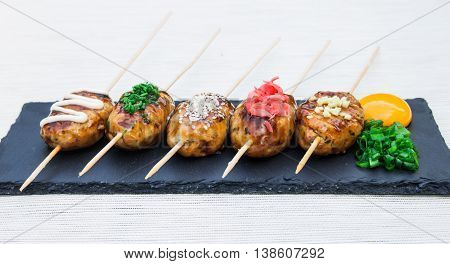 Japanese skewers of chicken with soy sauce and sesame seeds.