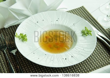 Consomm soup with Vegetable in a white dish