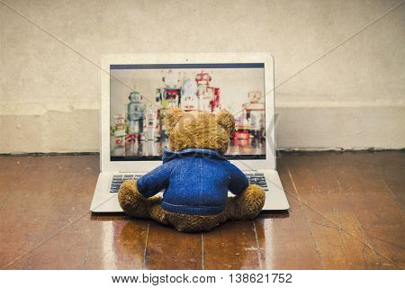 teddy bear watching a film on a laptop computer 