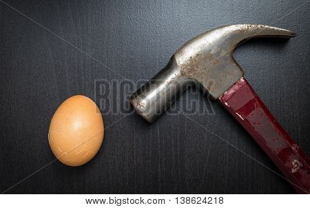Hammering a broken Egg on black table.