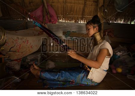 CHIANG MAI, TAILAND - APRIL 22, 2016: A portrait of a woman working at loom in Kayan Lahwi tribe known for wearing neck rings, brass coils to extend the neck. Kayan, Red Karen (Karenni). 